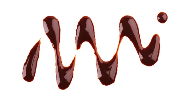 Schokoladensirup tröpfelt isoliert auf weißem Hintergrund. Spritzer süße Schokoladensoße. Ansicht von oben. — Stockfoto