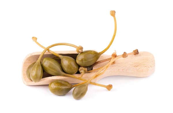 Kapary v dřevěné lžíci, izolované na bílém pozadí. Pickled capers. Konzervované kapary. — Stock fotografie