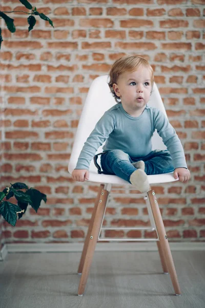 Toddler sitting in chair. — Stock Photo, Image