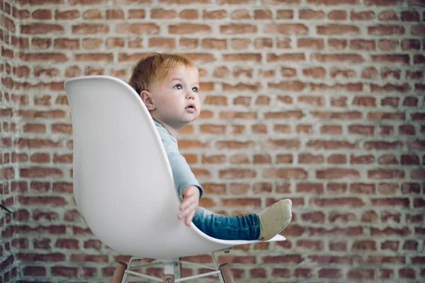 Toddler sitting in chair. — Stock Photo, Image