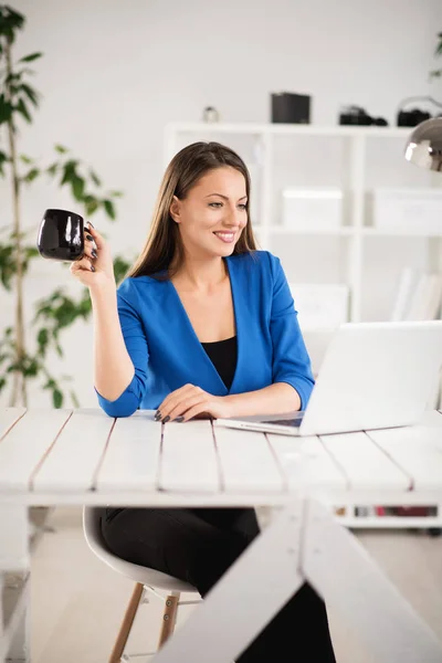 Mujer joven beber café y el uso de ordenador portátil — Foto de Stock