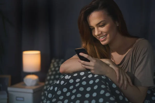 Žena používající chytrý telefon doma — Stock fotografie