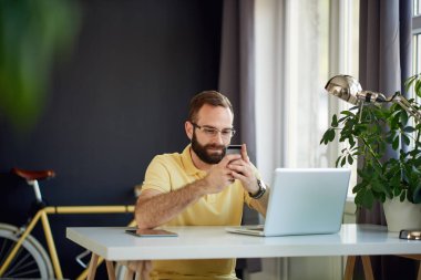 Dizüstü bilgisayarda çalışan genç adam.