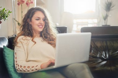 Evde dizüstü bilgisayarda çalışan bir kadın.