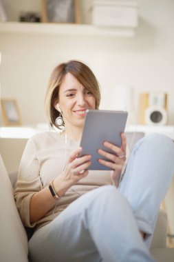 Tablet kullanan genç bir kadın. 