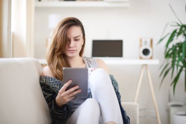 Tablet kullanan genç bir kadın.  