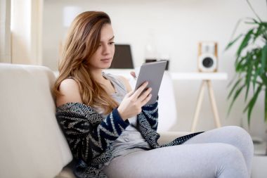 Tablet kullanan genç bir kadın.  
