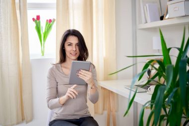 Tablet kullanan genç bir kadın. 