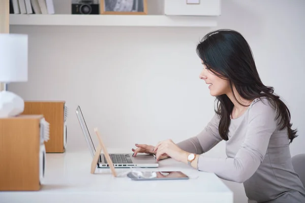 Junge Frau arbeitet zu Hause mit Laptop — Stockfoto