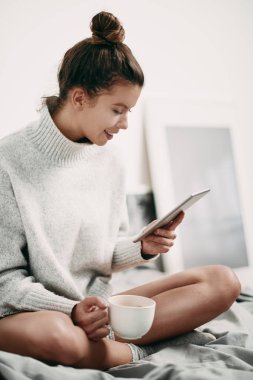 genç kadın yatakta yatan tablet kullanma 