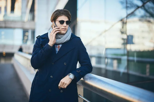 Joven hombre de negocios usando el teléfono inteligente mientras está de pie en la calle — Foto de Stock