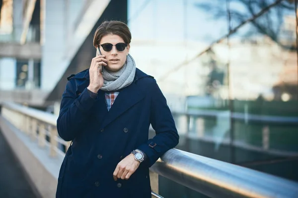 Joven hombre de negocios usando el teléfono inteligente mientras está de pie en la calle — Foto de Stock