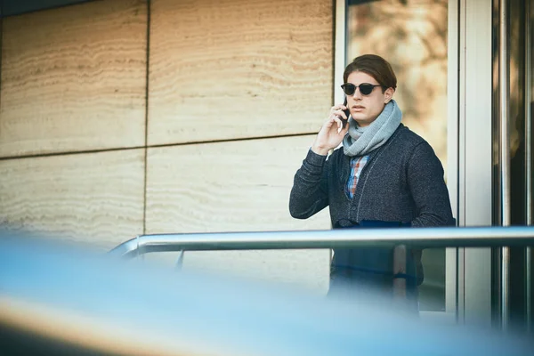 Joven hombre de negocios usando el teléfono inteligente mientras está de pie en la calle — Foto de Stock