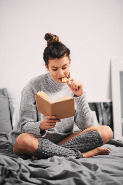 Frau Liest Buch Während Sie Morgens Auf Dem Bett Sitzt — Stockfoto