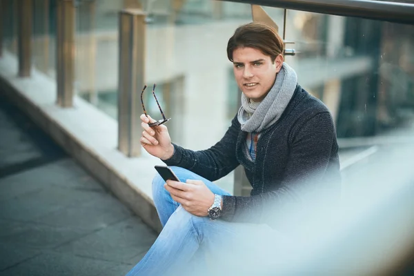 Açık Kullanma Akıllı Telefon Oturan Genç Adam — Stok fotoğraf