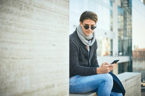 Ung Mand Sidder Udendørs Bruger Smart Telefon - Stock-foto