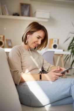 Genç güzel kadın kanepede oturan ve dijital tablet kullanma 