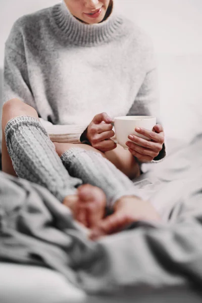 Nő ülve az ágyon, a reggeli kávét iszik. — Stock Fotó