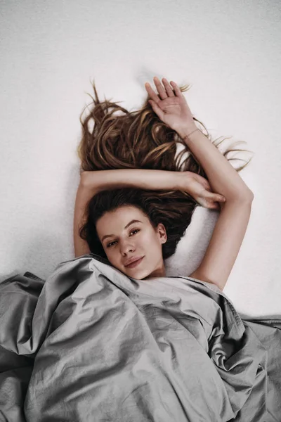 Девочка, лежащая на кровати утром — стоковое фото