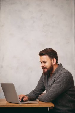 İş için dizüstü bilgisayar kullanarak ve kafede oturan adam