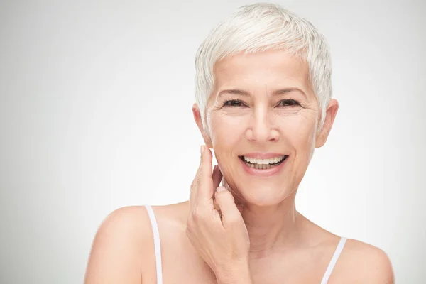 Portrait of beautiful senior woman in front of white background. — Stock Photo, Image