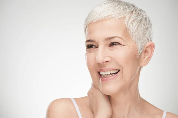 Portrait of beautiful senior woman in front of white background. Stock Photo