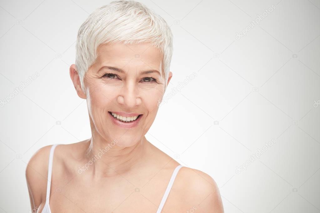 Portrait of beautiful senior woman in front of white background.