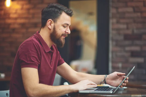 Uomo seduto nel caffè e utilizzando il computer portatile per lavoro . — Foto Stock