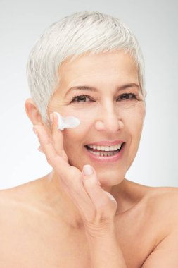 Kremayı koyarak güzel kadın kıdemli baş shot.