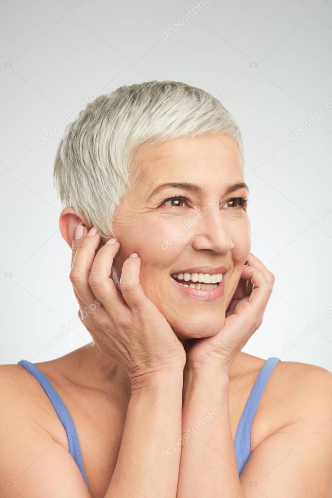 Portrait of beautiful senior woman in front of white background.