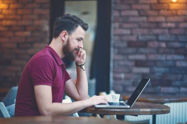 Kafede otururken dizüstü bilgisayar ve akıllı telefon kullanan adam. Yeni teknoloji