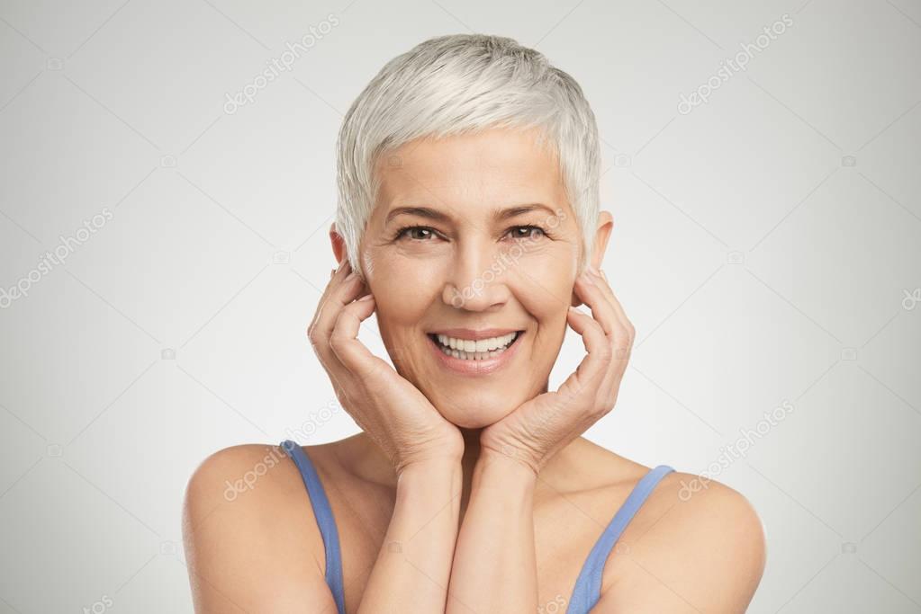 Portrait of beautiful senior woman in front of white background.