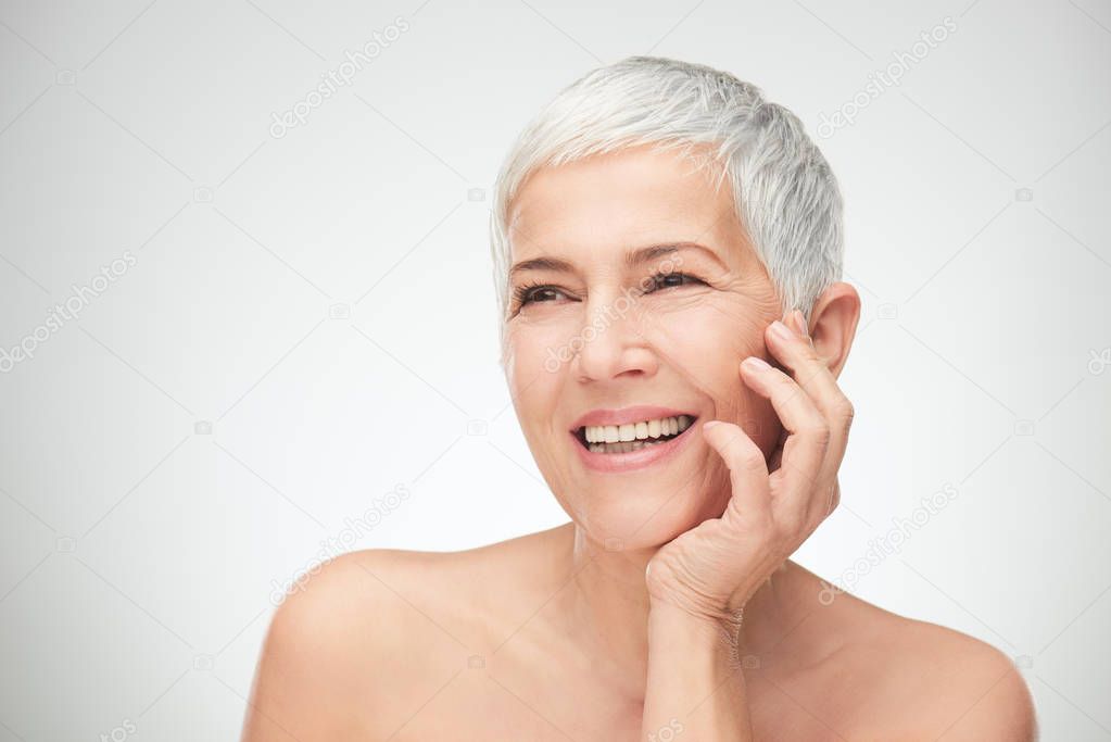 Portrait of beautiful senior woman in front of white background.