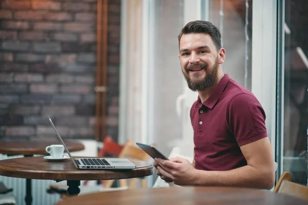 Jonge man zitten in de cafetaria en het gebruik van tablet pc — Stockfoto