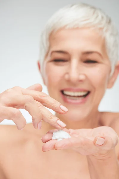 Close up of senior woman`s hands applying cream. — Stock Photo, Image