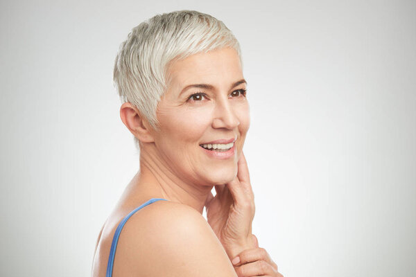 Portrait of beautiful senior woman in front of white background.