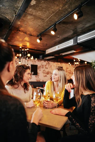 Подружки п'ють вино і спілкуються, сидячи в барі . — стокове фото
