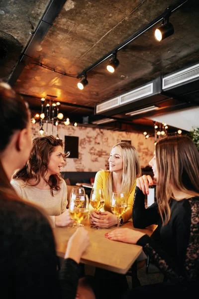 Vriendinnen wijn drinken en chatten tijdens de vergadering in de bar. — Stockfoto