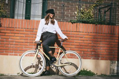 Şehrin bir bisiklet sürme genç modern kadın.
