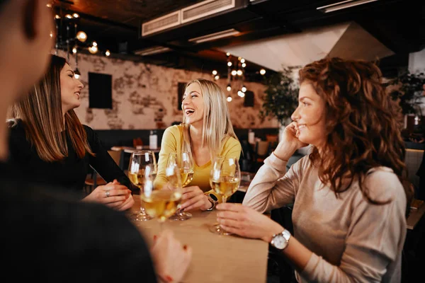 Vriendinnen wijn drinken en chatten tijdens de vergadering in de bar. — Stockfoto