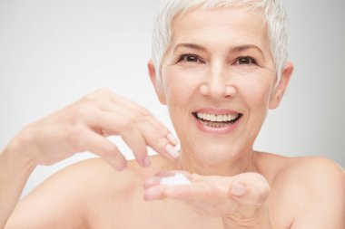 Kremayı koyarak güzel kadın kıdemli baş shot.