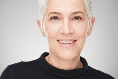 Beyaz arka plan önünde güzel kadın kıdemli portresi.