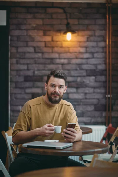 Jonge man zitten in Cafe en het gebruik van slimme telefoon. — Stockfoto