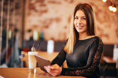 Kafede oturan ve kahve içme Yung kadın.