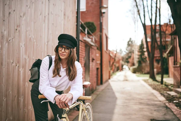 Joven mujer moderna montando en bicicleta en la ciudad . —  Fotos de Stock