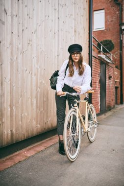 Güzel esmer holding Bisiklet portresi. Ahşap arka plan.