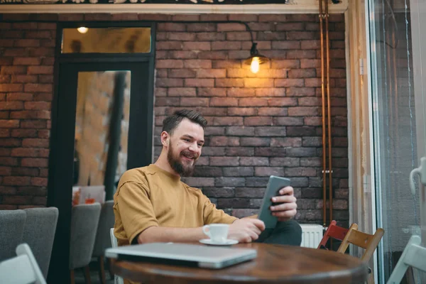 Hombre Usando Ordenador Portátil Teléfono Inteligente Mientras Está Sentado Cafetería — Foto de Stock