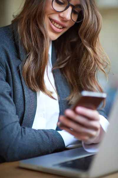 年轻的现代妇女坐在咖啡馆和使用智能手机 — 图库照片