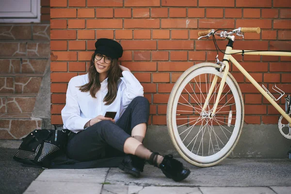 Mujer Sentada Acera Usando Teléfono Inteligente Junto Bicicleta Amarilla —  Fotos de Stock
