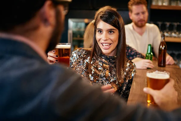 Grupa przyjaciół pije piwo, rozmawia i dobrze się bawi w pubie. Noc poza domem. — Zdjęcie stockowe
